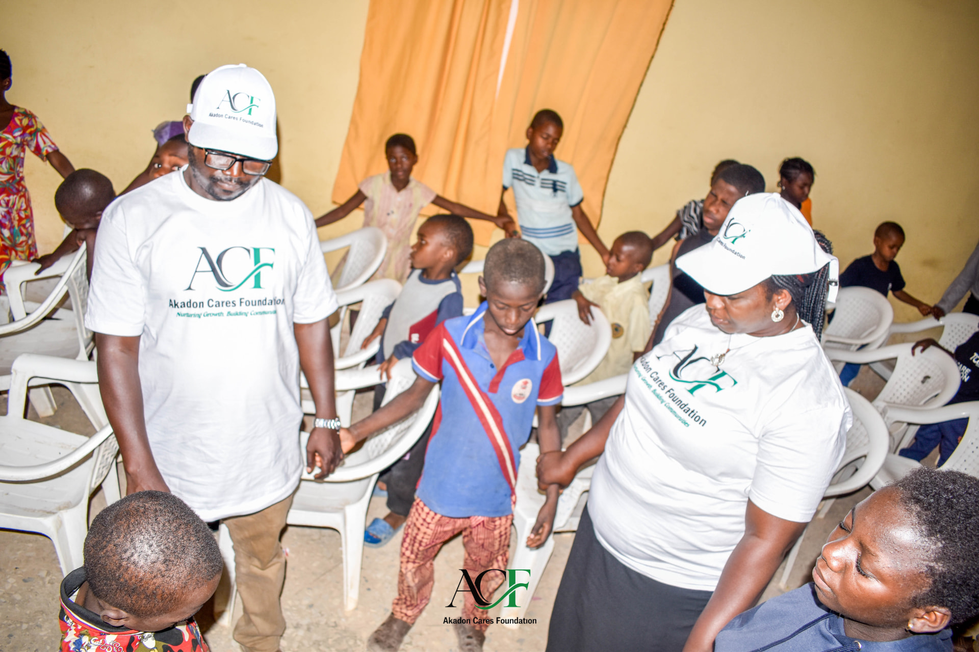ACF volunteers joining hands with children in a group activity